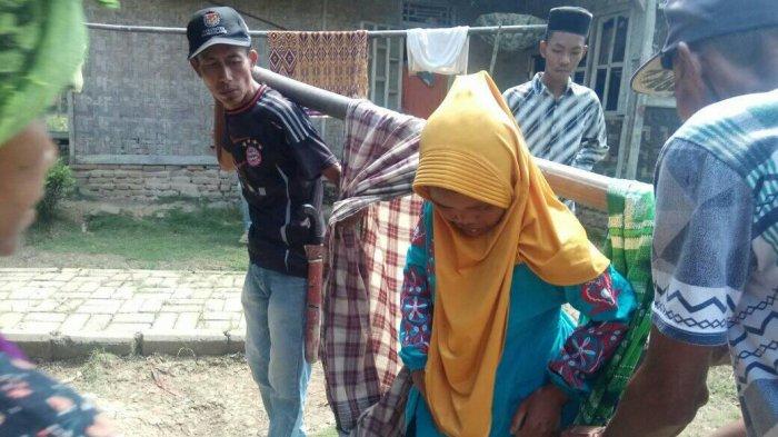 Enah (39) harus ditandu ke Puskesmas Sindangresmi, Kabupaten Pandeglang saat hendak melahirkan lantaran akses jalan ke rumahnya tidak bisa dilalui kendaraan roda empat, Sabtu (1/5/2021).