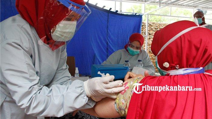 Seorang tenaga kesehatan (nakes) menjalani vaksinasi Covid-19 di Puskesmas Melur, Pekanbaru, Jumat (15/1/2021). (www.tribunpekanbaru.com/Doddy Vladimir)