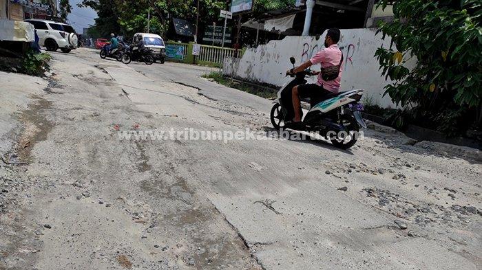 Kendaraan melintas di bekas galian perpipaan limbah rumah tangga di Jalan Melati, Kecamatan Sukajadi, Pekanbaru yang rusak, Selasa (13/4/2021).