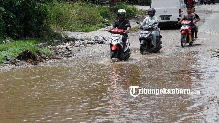 Sejumlah kendaraan saat melintas di Jalan Pemuda, Kecamatan Payung Sekaki, Pekanbaru yang rusak parah dan tergenang air, Selasa (18/8). Warga meminta kepada pemerintah terkait agar segera memperbaiki jalan yang rusak parah tersebut karena kondisi jalan rusak sudah berlangsung lama.