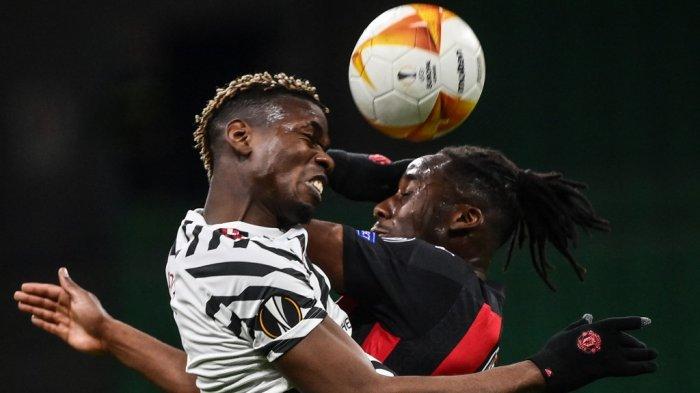 Paul Pogba (kiri) berebut bola dengan gelandang AC Milan Souhaliho Meite melakukan sundulan selama pertandingan sepak bola leg kedua babak 16 besar Liga Eropa UEFA antara AC Milan dan Manchester United di stadion San Siro di Milan pada 18 Maret 2021.