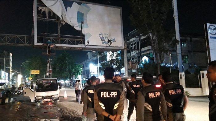 Anggota Satpol PP Pekanbaru mengawal pembongkaran bando reklame jalan, Selasa (21/1/2020) malam.