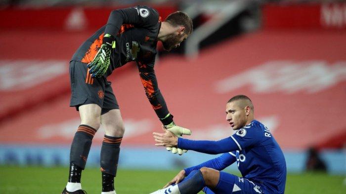 Penjaga gawang Manchester United David de Gea (kiri) membantu striker Everton Richarlison selama pertandingan sepak bola Liga Premier Inggris antara Manchester United dan Everton di Old Trafford di Manchester, barat laut Inggris, pada 6 Februari 2021.