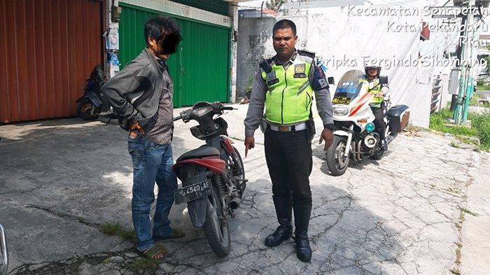 Anggota Satlantas Polresta Pekanbaru saat mengamankan sepeda motor yang menggunakan knalpot racing, Rabu (22/5/2019)/Istimewa