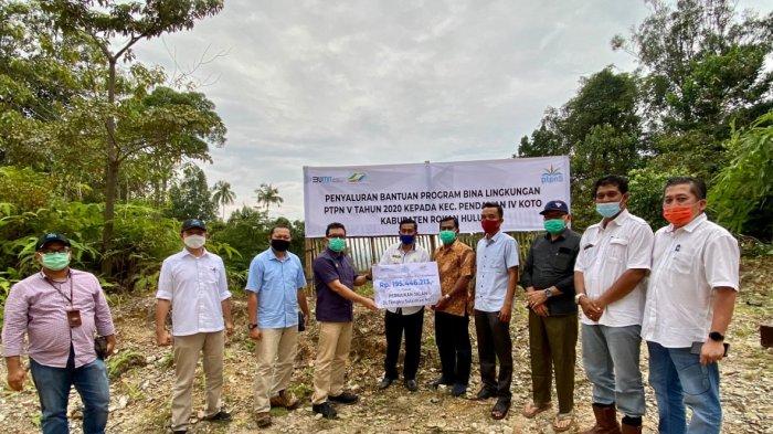 SEVP Business Support PTPN V Rurianto menyerahkan bantuan dana bina lingkungan untuk peningkatan kualitas jalan kepada Kepala Desa Pendalian Mulyadi, baru-baru ini di Kec. Pendalian IV Koto Rokan Hulu