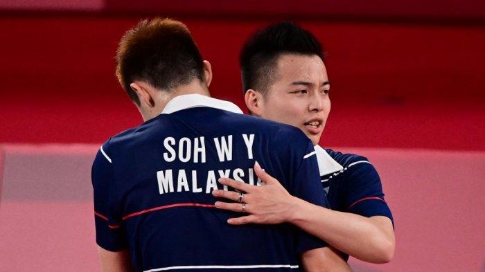 Soh Wooi Yik (kiri) dan Aaron Chia dari Malaysia berpelukan setelah memenangkan pertandingan perempat final bulu tangkis ganda putra melawan Kevin Sanjaya Sukamuljo dari Indonesia dan Marcus Fernaldi Gideon dari Indonesia selama Olimpiade Tokyo 2020 di Musashino Forest Sports Plaza di Tokyo pada 29 Juli 2021 .