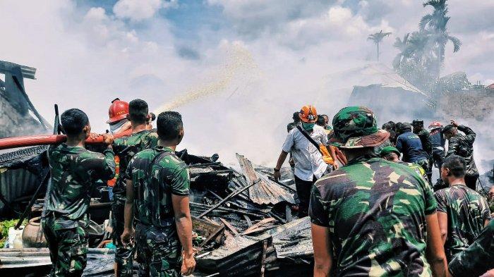 Tim pemadam beserta masyarakat berusaha memadamkan api dalam musibah kebakaran di Jalan A Yani Lr. Serta Daya RT.03 RW 10, Kelurahan Tembilahan Kota, Kecamatan Tembilahan, Kabupaten Inhil, Selasa (20/10) sekitar pukul 10.30 WIB.