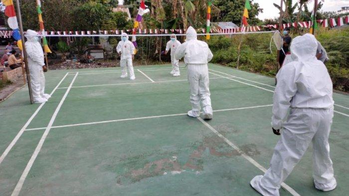 Warga menggelar perlombaan Badminton menggunakan seragam APD lengkap.