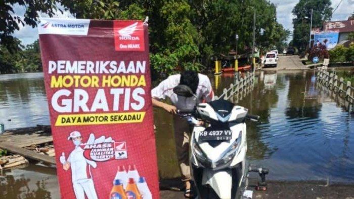Mekanik tersertifikasi Ahass di kabupaten Sekadau tengah memeriksa kendaraan yang mengalami kendala setelah melewati genangan banjir di sekadau.