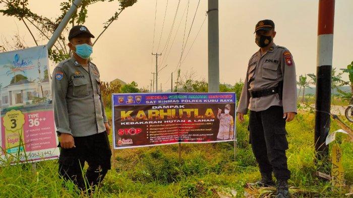 Personil Satuan Binmas Polres Kubu Raya melakukan pemasangan Spanduk Himbauan Bahaya Karhutla di tiga titik di desa yang dianggap rawan terjadinya kebakaran Hutan dan Lahan di wilayah hukum Polres Kubu Raya, Rabu 17 Februari 2021.