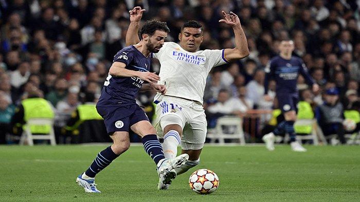 Gelandang Manchester City asal Portugal, Bernardo Silva (kiri) berebut bola dengan pemain tengah Real Madrid asal Brazil, Casemiro pada pertandingan leg kedua semifinal Liga Champions antara Real Madrid CF dan Manchester City di stadion Santiago Bernabeu di Madrid, Kamis 5 Mei 2022 dini hari WIB.