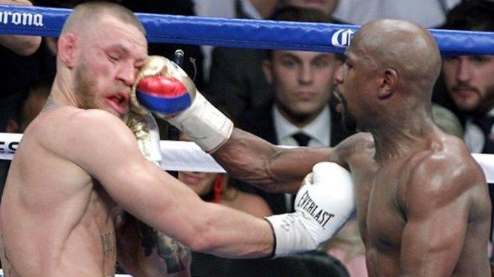 Floyd Mayweather Jr melepaskan pukulan ke arah wajah Conor McGregor pada pertarungan yang bertajuk The Money Fight yang digelar di T-Mobile Arena, Paradise, Nevada, Amerika Serikat, 26 Agustus 2017. Floyd Mayweather petinju yang punya rekor tak pernah kalah