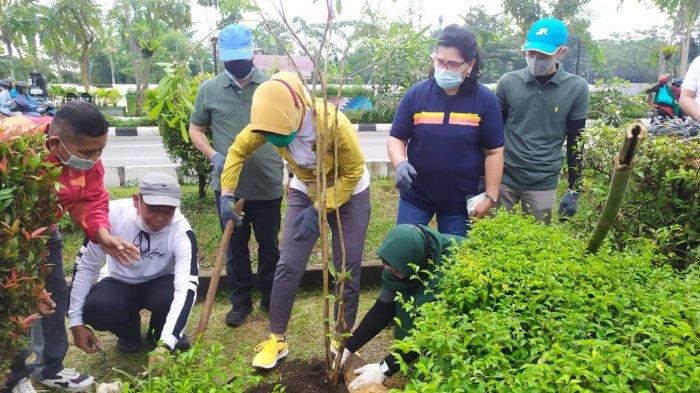 Istri Wali Kota Pontianak, Yeni Kamtono menanam pohon Tabebuya bersama Kepala Unit Keuangan, Akuntansi dan PKBL, Silvia Desri di kawasan Taman Catur, Pontianak, pada Jumat, 27 November 2020.