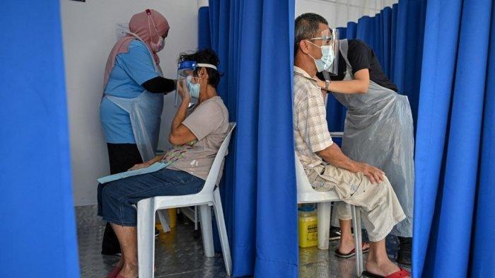 Warga menerima vaksin virus corona Covid-19 Sinovac di truk vaksin bergerak di Kuala Lumpur, Malaysia pada 21 Juni 2021. (Mohd RASFAN / AFP)