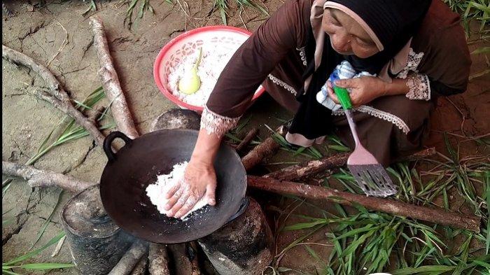 Perempuan paruh baya memasak gedah sagu menggunakan tangan di wajan panas di kawasan destinasi wisata Lae Trup, Rawa Singkil, Desa Teluk Rumbia, Kecamatan Singkil, Aceh Singkil, Selasa (7/7/2020).