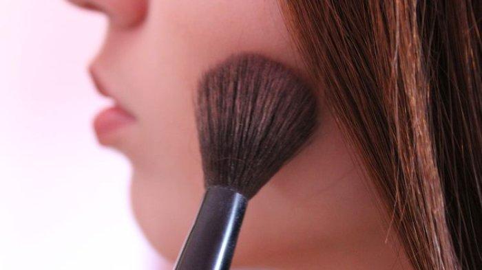 Ilustrasi wanita menggunakan bedak tabur menggunakan brush dengan bulu yang lembut dan nyaman digunakan.