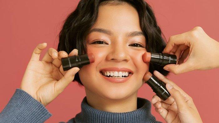 Ilustrasi wanita menggunakan blush on di wajah.