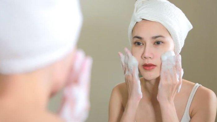 Ilustrasi seorang wanita membersihkan wajah dengan produk berusa, biasanya mengandung sulfat yang kurang baik untuk kulit kering.