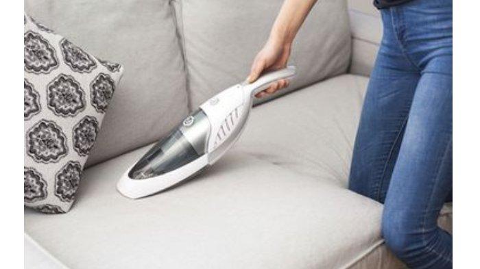 Ilustrasi membersihkan berbagai debu dan partikel yang menempel pada permukaan sofa dengan vacuum cleaner
