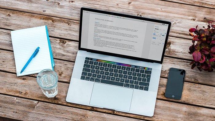 Ilustrasi perangkat laptop yang sedang membuka software pengolah kata dalam rangkaian aplikasi kantoran