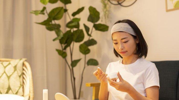 Ilustrasi seorang wanita mengaplikasikan produk skincare dengan kandungan squalane oil.