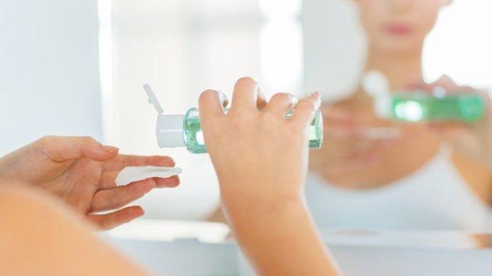 Ilustrasi wanita mengaplikasikan toner menggunakan kapas.
