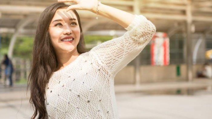 Ilustrasi seorang wanita yang beraktivitas di bawah terik matahari, dianjurkan untuk berteduhdi waktu tertentu dan melakukan re-apply sunscreen atau sunblock.