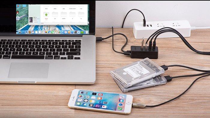 Ilustrasi pengguna yang sedang bertukar data antar laptop dan handphone