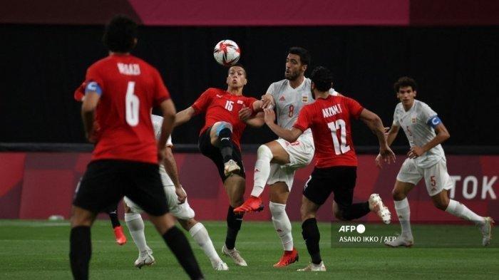 Pemain depan Mesir Emam Ashour (tengah L) bersaing memperebutkan bola dengan gelandang Spanyol Mikel Merino (tengah R) selama pertandingan sepak bola putaran pertama grup C putra Olimpiade Tokyo 2020 antara Mesir dan Spanyol di Sapporo Dome di Sapporo pada 22 Juli 2021. ASANO IKKO / AFP