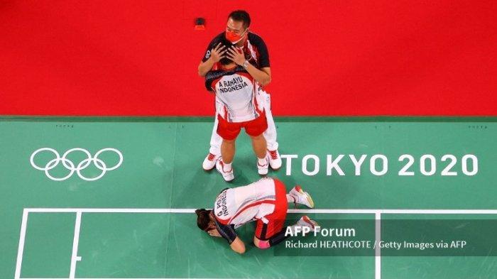 Ganda putri Indonesia, Greysia Polii dan Apriyani Rahayu berselebrasi bersama pelatih Eng Hian setelah mereka memenangkan laga melawan ganda putri Cina, Chen Qing Chen dan Jia Yi Fan dalam perebutan medali emas Olimpiade Tokyo 2020 di Musashino Forest Sport Plaza, 2 Agustus 2021. (Richard Heathcote/Getty Images/AFP).