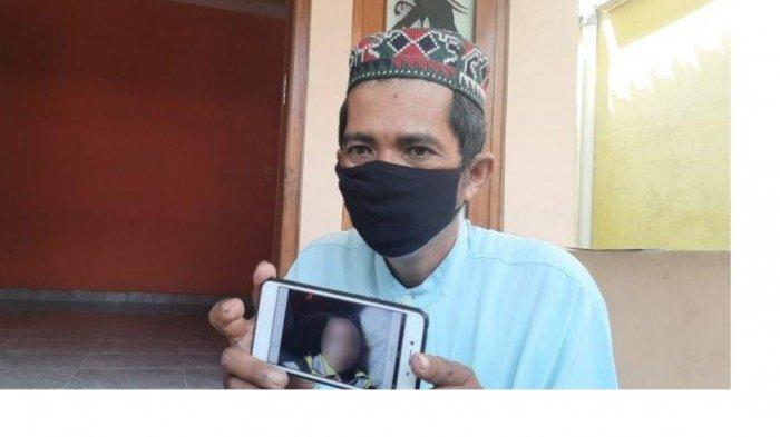 Bandiman memperlihatkan foto anaknya yang meninggal usai menyantap paket sate misterius, Senin (26/4/2021)