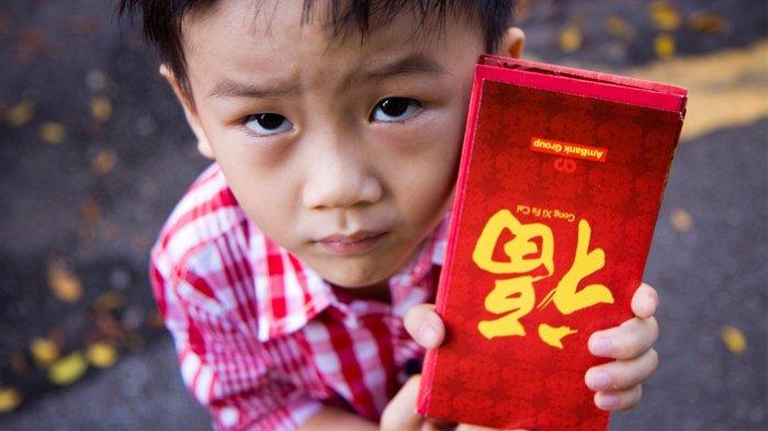 Anak kecil menerima angpao.