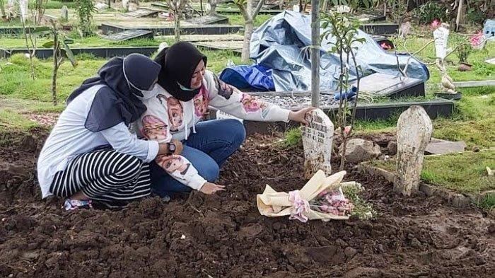 Erlita Dewi menangis di atas makam putri sulungnya, Agita Cahyani Putri di kompleks pemakaman Praloyo Sidoarjo, Jumat (2/4/2021) siang.