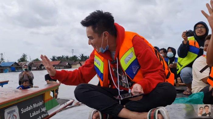 Potret Baim Wong naik perahu untuk salurkan bantuan
