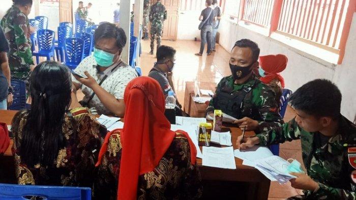 TNI-AD terlihat melayani seorang warga yang ingin mengikuti vaksinasi massal di Desa Sari Mukti, Kecamatan Langkikima, Konawe Utara, Sulawesi Tenggara, Jumat (20/8/2021).