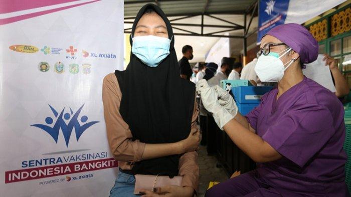 Vaksinator sedang menyuntikkan vaksinasi Covid-19 kepada warga di Sentra Vaksinasi Indonesia Bangkit yang berlangsung di Kantor Kecamatan Medan Selayang, Kota Medan, Sumatera Utara.