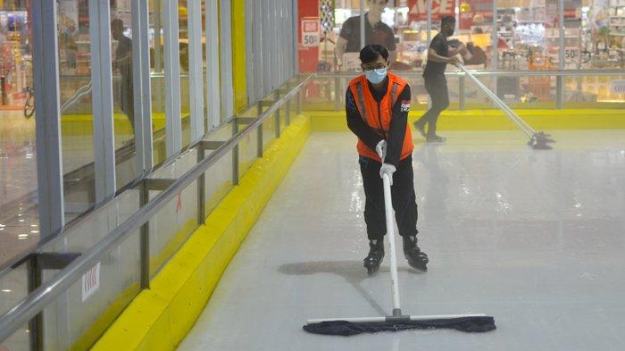 Riando, Seorang rink guard mengepel arena ice skating untuk kenyamanan dan keamanan saat bermain.