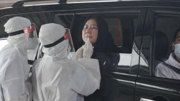 Ketua Dharma Wanita Kota Surabaya Chusnur Ismiati Hendro Gunawan mencoba layanan Drive - Thru Swab PCR NeoClinic di Jalan Mayjen Sungkono Nomor 153, Surabaya, Minggu (17/1/2021).