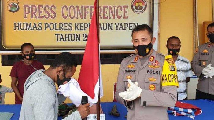 CIUM MERAH PUTIH - Noak Orarei, pimpinan kelompok kriminal bersenjata (KKB) Wilayah Distrik Kosiwo, Kabupaten Kepulaun Yapen, Provinsi Papua, saat melakukan ikrar setia NKRI sambil mencium bendera merah putih di Mapolres Yapen, Rabu (17/3/2021).