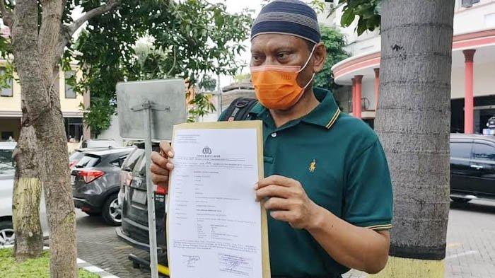 Ayah Korban menunjukkan surat tanda bukti laporan polisi usai mendampingi putrinya diperiksa atas kasus dugaan pencabulan di Mapolrestabes Surabaya, Rabu (3/3/2021). (SURYA.CO.ID/Firman Rachmanudin)