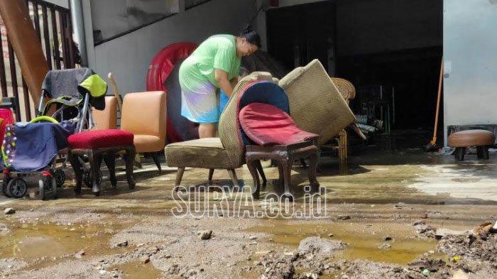 Warga membersihkan rumah mereka usai banjir melanda kawasan Lowokwaru Kota Malang, Selasa (5/1/2021).