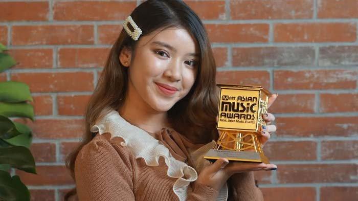 Tiara Andini memperlihatkan penghargaan Mnet Music Awards (MAMA) 2020.