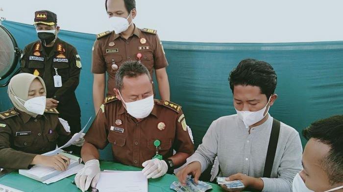 Alvan (27), pemilik Kafe Java, menghitung uang denda Rp 5 juta yang dibayar kontan