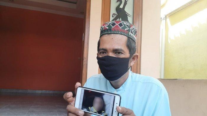 Bandiman memperlihatkan foto anaknya, meninggal usai menyantap paket sate, Senin 26 April 2021