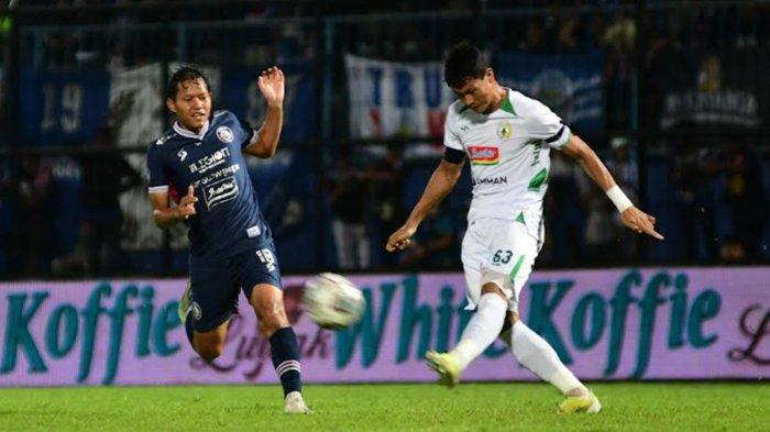 Pesepakbola PSS Dedy Gusmawan menghalau bola dari serangan pesepakbola Arema FC Adam Alis dalam laga lanjutan Liga 1 2022 di Stadion Kanjuruhan, Kabupaten Malang, Jumat (5/8/2022).