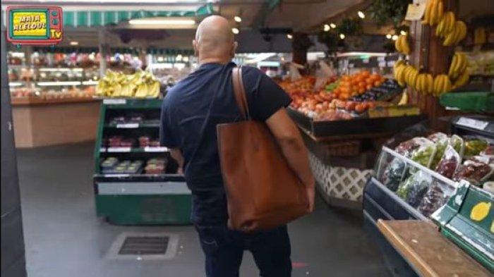 Gaya Irwan Mussry saat membawakan tas Maia Estianty ketika belanja