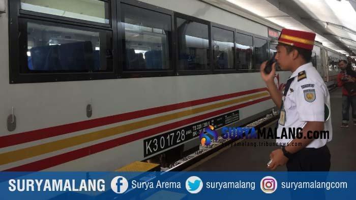 Seorang petugas di Stasiun Malang sedang mengatur perjalanan kereta api