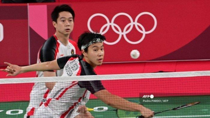 Pemain Indonesia, Marcus Fernaldi Gideon melakukan pukulan di sebelah partnernya, Kevin Sanjaya Sukamuljo, melawan wakil Malaysia, Soh Wooi Yik dan Aaron Chia dalam pertandingan perempat final Olimpiade Tokyo 2020 di Musashino Forest Sports Plaza di Tokyo pada 29 Juli 2021.