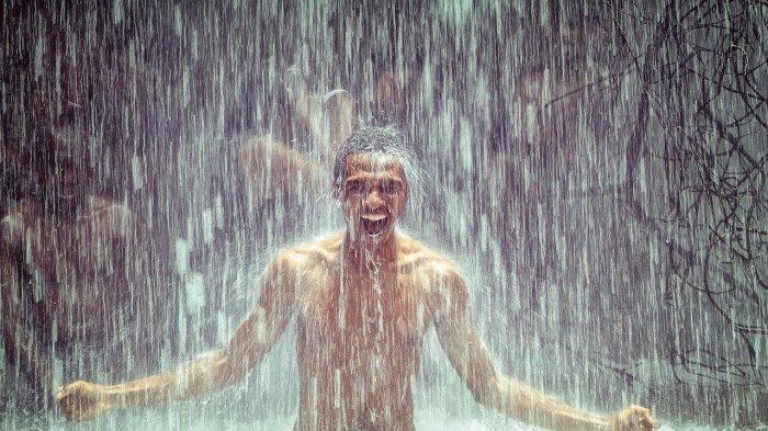 Ilustrasi pria yang berada di bawah air terjun