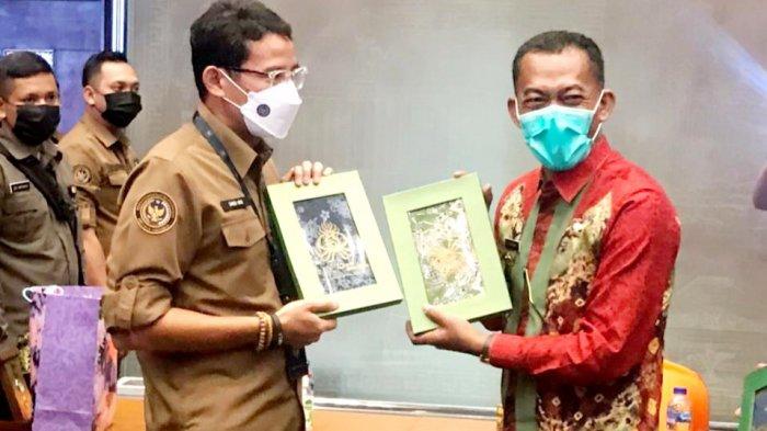 Menteri Pariwisata Ekonomi Kreatif, Sandiaga Uno (kiri) menerima suvenir dari Bupati Subang, H Ruhimat di Kantor Kemenparekraf, Jakarta, Rabu (20/5/2021)
